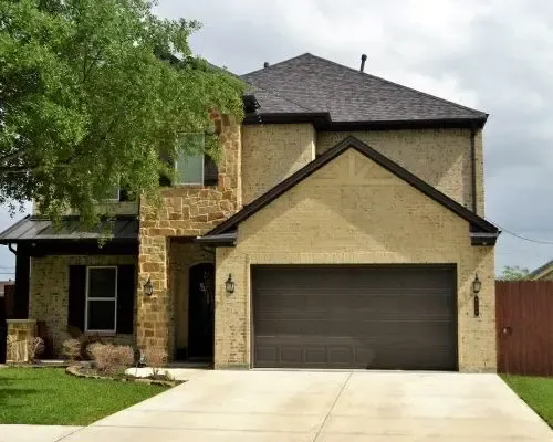 Two-storey home with a new brown sectional garage door